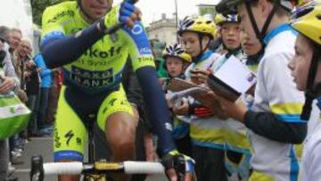 Contador atiende a unos niños a la espera de recortar tiempo a Nibali en los Vosgos.
