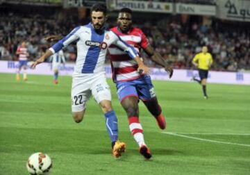 El defensa del Espanyol, Álvaro González disputa un balón con el delantero nigeriano del Granada, Isaac Success, durante el encuentro correspondiente a la jornada 34 de primera división, que disputan esta noche en el estadio Nuevo los Cármenes de Granada. 