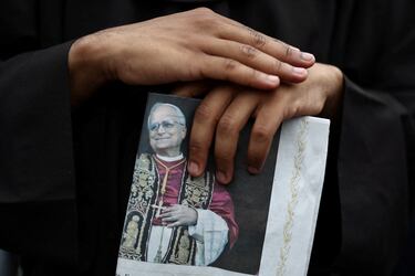 Una persona sostiene un ejemplar de L'Osservatore Romano con una imagen del Papa León XIV mientras dirige una oración del Regina Caeli desde el balcón central (Loggia delle Benedizioni) de la Basílica de San Pedro, en el Vaticano.
