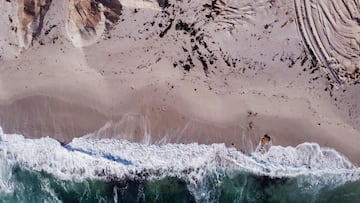Vista aérea con las marcas de la excavadora en la playa de la mina de Moonstone, en Doringbaai (Sudáfrica) el 22 de septiembre del 2022. Con flamencos, arena blanca, aguas cristalinas... y dicen que diamantes en todo el estuario del río Olifants, que desemboca en el Océano Atlántico a unos 300 kilómetros al norte de Ciudad del Cabo. (Photo by WIKUS DE WET / AFP)