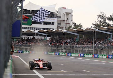 La bandera de cuadros ondea ante el paso de Carlos Sainz por la línea de meta para ganar el GP de México.