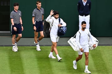 Carlos Alcaraz y Novak Djokovic saludan al público reunido en la pista central de Wimbledon.