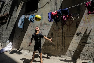 Un niño palestino juega al fútbol frente a su casa en el campo de refugiados de Al-Shati, el tercero más grande de los territorios palestinos.