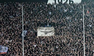 A picture taken on March 11, 2018, shows PAOK's supporters gesturing and cheering during the Greek Superleague football match between PAOK Thessaloniki and AEK Athens at the Toumba Stadium in Thessaloniki.