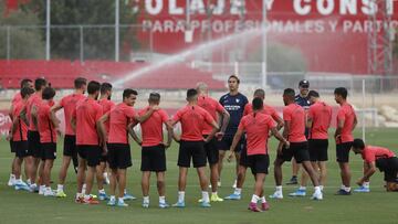 Los jugadores del Sevilla escuchan sobre el c&eacute;sped las indicaciones de su entrenador, Julen Lopetegui. 