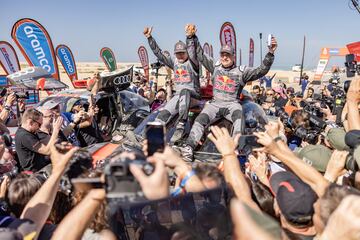 Carlos Sainz siempre tuvo el don de aparentar normalidad ante lo extraordinario. Sin embargo, su cuarta conquista del Dakar nunca trascendió como un triunfo cualquiera por varias razones. Para empezar, el piloto español se superó a sí mismo como ganador más longevo en la carrera (62 años); se convirtió en el primer piloto que conquistó el Touareg con cuatro marcas diferentes (Volkswagen, Peugeot, Mini y Audi) y junto a un coche de “ciencia ficción” con propulsión eléctrica coronó el proyecto de la marca de los cuatro aros en el desierto. Un segundo hogar para el madrileño en el que habla el idioma de la velocidad y al que se vuelve a presentar con otro nuevo objetivo: una nueva corona.