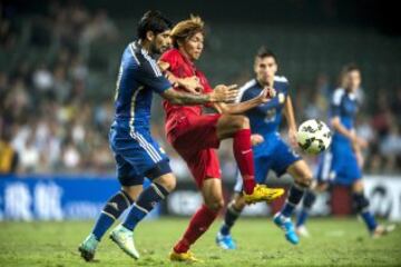 El jugador argentino Ever Banega pelea por el control del balón con el jugador de la selección de Hong Kong, Lee Chi Ho, durante el partido amistoso disputado en Hong Kong