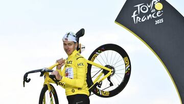 El ciclista esloveno Tadej Pogacar, del UAE Team Emirates - XRG, celebrando en el podio con el maillot amarillo de líder de la general y su bicicleta la victoria en el Tour de Francia.