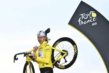 El ciclista esloveno Tadej Pogacar, del UAE Team Emirates - XRG, celebrando en el podio con el maillot amarillo de líder de la general y su bicicleta la victoria en el Tour de Francia.