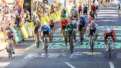 Dylan Groenewegen (de rojo, a la derecha) vence a Jasper Philipsen (de gris, a la izquierda) en la meta de Dijon. Los dos se interrogan con la mirada.