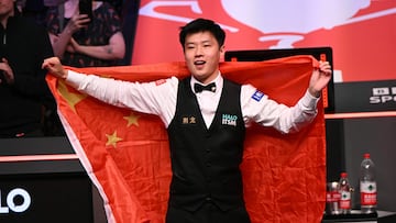 China's Zhao Xintong poses with the Chinese flag after victory over Wales' Mark Williams in the World Championship Snooker final at The Crucible in Sheffield, northern England on May 5, 2025. (Photo by Oli SCARFF / AFP)