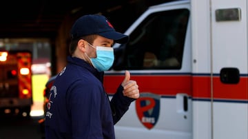 A Fenway Park employee directs a convoy of 50 ambulances in to Fenway Park in celebration of National EMS Week on May 20, 2020 in Boston, Massachusetts.