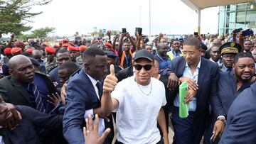 Paris Saint-Germain and France national football team star striker Kylian Mbappe (C) greets crowds gathered outside at the Yaounde Airport in Yaounde on July 6, 2023 as he arrives for a charity visit and a tour of his father's village. (Photo by Daniel BELOUMOU OLOMO / AFP)