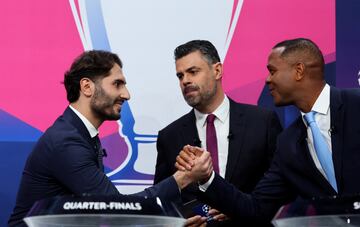 Los embajadores de la UEFA. los exjugadores Patrick Kluivert y Hamit Altıntop se saludan antes dar comienzo el sorteo.