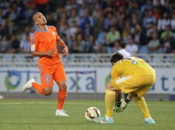 Valencia's French midfielder Sofiane Feghouli (L) vies for the ball with Real Sociedad's goalkeeper Enaut Zubikarai (R) during the Spanish league football match Real Sociedad vs Valencia CF at the Anoeta stadium in San Sebastian on September 28, 2014. AFP PHOTO / ANDER GILLENEA