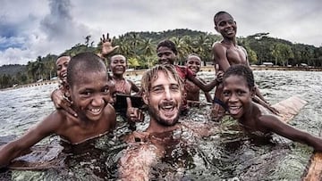 El fot&oacute;grafo de surf Brad Masters ba&ntilde;&aacute;ndose con unos ni&ntilde;os en &Aacute;frica.