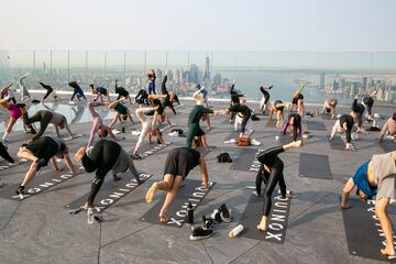 Un grupo de personas hace yoga en la azotea de un edificio de Manhattan (Nueva York). Como ocurre con muchos tipos de ejercicios al aire libre, esta pr¨¢ctica cogi¨® gran demanda durante la pandemia del coronavirus, y no se ha pasado de moda, sino m¨¢s bien al contrario: hay semanas de lista de espera para asistir a las clases.
