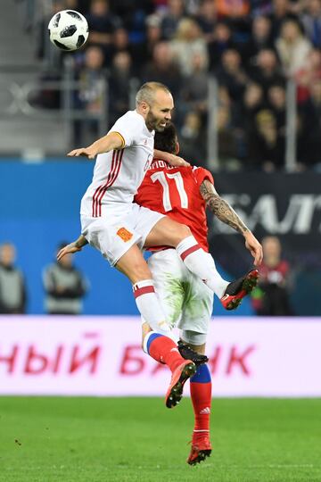 Iniesta jumps for the ball with Smolov.