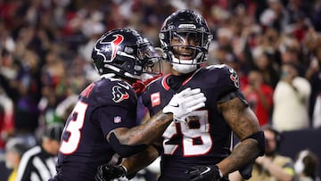 HOUSTON, TEXAS - JANUARY 11: Joe Mixon #28 of the Houston Texans celebrates with teammate Del'Shawn Phillips #13 after scoring a touchdown against the Los Angeles Chargers during the AFC Wild Card Playoffs at NRG Stadium on January 11, 2025 in Houston, Texas. Alex Slitz/Getty Images/AFP (Photo by Alex Slitz / GETTY IMAGES NORTH AMERICA / Getty Images via AFP)