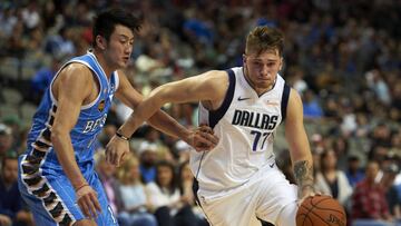 FILE - In this Saturday, Sept. 29, 2018, file photo, Dallas Mavericks guard Luka Doncic (77) drives to the basket against Beijing Ducks forward Duan Jiangpeng (11) during the second half of an NBA exhibition basketball game in Dallas. Doncic has help from plenty of angles as a teenager transitioning from European ball to the NBA with the Mavericks. (AP Photo/Cooper Neill, File)
