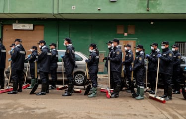 Alumnos de la Escuela Nacional de Policía con escobas en una de las zonas afectadas por la DANA en Alaquàs, Valencia.
