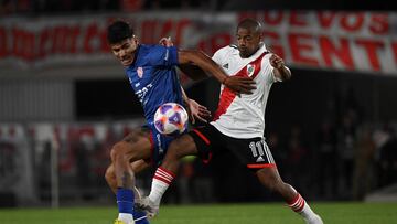 River Plate's midfielder Nicolas De La Cruz (R) vies for the ball with Union's forward Junior Marabel during their Argentine Professional Football League Tournament 2023 match at El Monumental stadium, in Buenos Aires, on March 31, 2023. (Photo by LUIS ROBAYO / AFP)