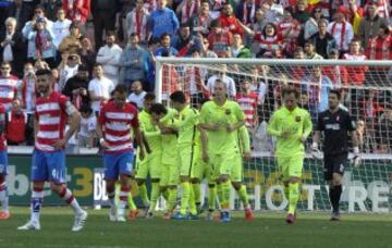 El delantero argentino del Barcelona Lionel Messi celebra con sus compañeros el gol que acaba de marcar, el tercero para el equipo, durante frente el partido frente al Granada de la vigésima quinta jornada de Liga de Primera División que se juega hoy en el estadio Nuevo Los Cármenes de Granada.