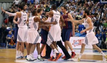 El pívot croata del FC Barcelona Ante Tomic (i) durante la trifurca con el ala-pívot estadounidense del Real Madrid Marcus Slaughter (3d).