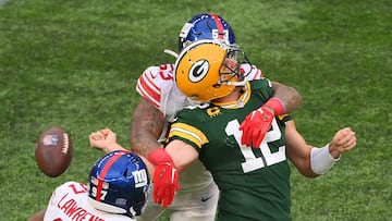 LONDON, ENGLAND - OCTOBER 09: Aaron Rodgers #12 of the Green Bay Packers is sacked by Oshane Ximines #53 of the New York Giants and fumbles the ball in the fourth quarter during the NFL match between New York Giants and Green Bay Packers at Tottenham Hotspur Stadium on October 09, 2022 in London, England.   Mike Hewitt/Getty Images/AFP