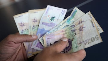 FILE PHOTO: A employee counts Colombian pesos at a store in Bogota, Colombia December 28, 2018. REUTERS/Luisa Gonzalez//File Photo