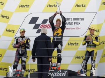 Esteve Rabat sostiene el trofeo en el podio después de ganar la carrera de Moto2, seguido de su compañero de equipo el finlandés Mikka Kallio en segundo lugar y el piloto español Maverick Viñales, en tercer lugar en el GP de motociclismo de Gran Bretaña en Silverstone