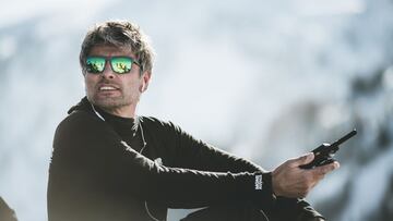 El director del Freeride World Tour, Nicolas Hale-Woods, con gafas de sol y con un walkie, en una montaña con nieve.