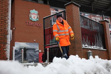 Un trabajador limpia la nieve fuera del estadio antes del inicio del encuentro.