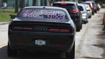 MIAMI SPRINGS, FLORIDA - JULY 16: A car with, ' extend $600 now!', written on the rear window participates in a caravan protest on July 16, 2020 in Miami Springs, Florida. The caravan was driving to the Coral Gables office of Sen. Rick Scott to