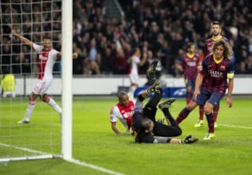 El portero del FC Barcelona, Jose Manuel Pinto (c) y el defensa Carles Puyol (d) lamentan el primer gol marcado por Thulani Serero del Ajax de Amsterdam durante el partido correspondiente a la fase de grupos de la Liga de Campeones disputado en el Amsterdam Arena