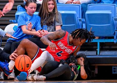 A veces el baloncesto podría considerarse un deporte de riesgo. Y si no, que se lo pregunten a la fotógrafa de la imagen. El jugador de los Radford Highlanders Truth Harris aterrizó sobre ella al intentar alcanzar un balón sin dueño durante el partido contra los Tar Heels en el Dean E. Smith Center, en Chapel Hill (Carolina del Norte).