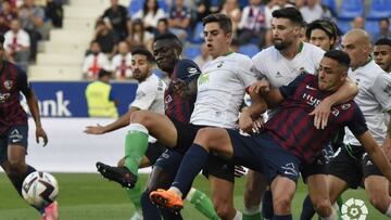 Íñigo y Satrústegui. del Racing, defendiendo una acción a balón parado en Huesca.