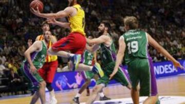 El base italiano del Barcelona Marcelinho Huertas (c), entra a canasta ante los jugadores del Unicaja, el pívot montenegrino Vladimir Golubovic (i), el base serbio Stefan Markovic (2d), y el alero lituano Mindaugas Kuzminskas (d).