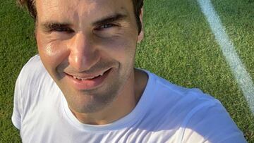 Roger Federer se hace una selfi sobre una pista de hierba tras un entrenamiento.