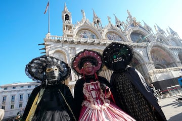 Turistas visten m¨¢scaras tradicionales del carnaval de Venecia en la plaza de San Marcos en el centro de la ciudad.