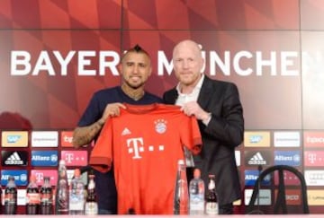 Arturo Vidal posa con su nueva camiseta del Bayern Munich junto al director deportivo del club, Matthias Sammer.