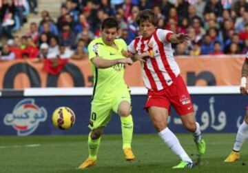 El delantero argentino del FC Barcelona Lionel Andrés Messi (i) y el defensa argentino del Almeria Sebastian Dubarbier luchan por el balón durante el partido correspondiente a la undécima jornada de Liga de Primera División que disputan en el estadio de los juegos Mediterraneos de Almería.