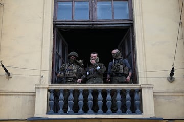 Los combatientes del grupo mercenario privado de Wagner se paran en un balcón mientras están desplegados en la sede del Distrito Militar del Sur en la ciudad de Rostov. 