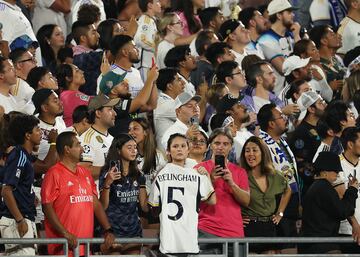 Una aficionada sostiene una camiseta de Bellingham en la grada.