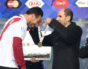 Peru's forward Claudio Pizarro (L) recevies a medal on the podium at the end of their Copa America third place football match against Paraguay in Concepcion, Chile on July 3, 2015. Peru won 2-0. AFP PHOTO / LUIS ACOSTA
