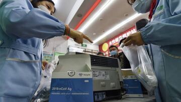 This photo taken on December 15, 2022 shows staff members preparing antigen test kits at a pharmacy amid the Covid-19 pandemic in Nanjing, in China's eastern Jiangsu province. - China OUT (Photo by AFP) / China OUT (Photo by STR/AFP via Getty Images)