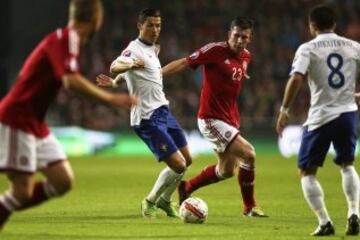 Pierre-Emile Hojbjerg de Dinamarca disputa el balón con Cristiano Ronaldo de Portugal, durante un partido de clasificación para la Eurocopa 2016 en el estadio Parken de Copenhague