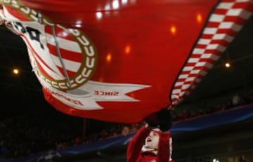 A PSV supporter waves a flag prior to the  Champions League round of 16 first leg soccer match between PSV Eindhoven and Atletico Madrid at the Philips stadium in Eindhoven, Netherlands, Wednesday, Feb. 24, 2016.