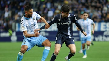 Málaga (España) 07/01/2024.- El delantero de la Real Sociedad Carlos Fernández (d) disputa un balón ante el defensa del Málaga CF Einar Galilea (i) durante el partido que enfrenta hoy domingo al Málaga CF y a la Real Sociedad en el estadio de La Rosaleda en dieciseisavos de final de la Copa del Rey. EFE/Daniel Pérez