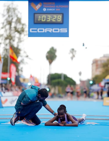 Agnes Ngetich cae al suelo tras pasar por la línea de meta del Medio Maratón Valencia Trinidad Alfonso.